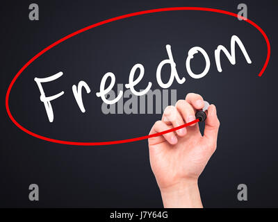 Man mano che scrive la libertà con il pennarello nero su schermo visivo. Isolato su nero. Business, tecnologia internet concetto. Immagine di stock Foto Stock