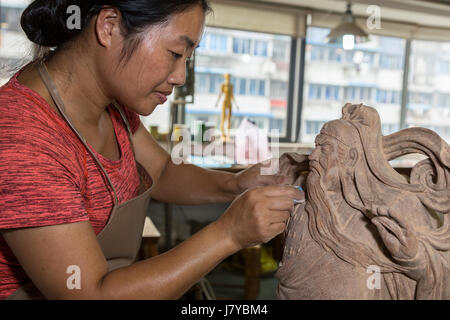 Wenzhou, Zhejiang, Cina. Intagliatore di legno di bosso Carving la figura di Leader militari Guan Yu, arti e mestieri Istituto di ricerca. Foto Stock