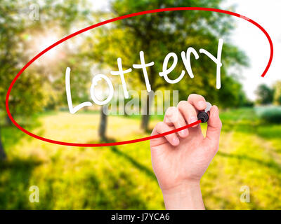 Man mano che scrive lotteria con pennarello nero su schermo visivo. Isolato sulla natura. Business, tecnologia internet concetto. Stock Photo Foto Stock