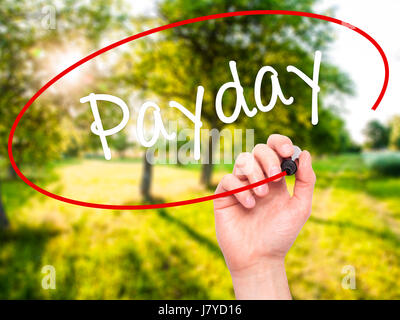 Man mano che scrive Payday con pennarello nero su schermo visivo. Isolato sulla natura. Business, tecnologia internet concetto. Stock Photo Foto Stock