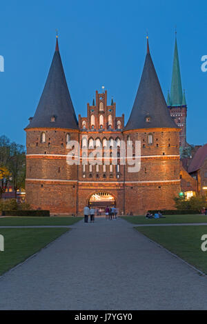 Holstentor, porta della città al tramonto, Città anseatica Lübeck, Schleswig-Holstein, Germania Foto Stock