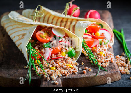 Deliziosi piatti vegetariani tortilla con verdure fresche e semole Foto Stock