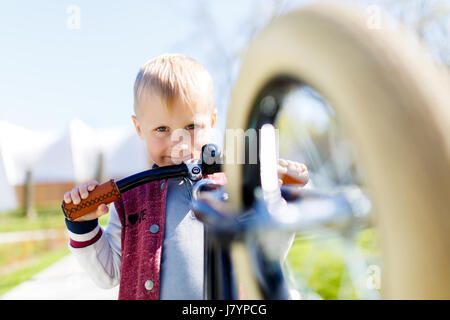 Ragazzo con run bike nel parco durante il giorno Foto Stock