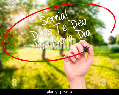 Man mano che scrive Sorria! Deus Te Deu Um Novo Dia (sorriso! Dio vi dà un altro giorno in portoghese) con pennarello nero su schermo visivo. Isolato su natu Foto Stock