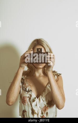 Donna che mantiene una fotocamera vintage Foto Stock
