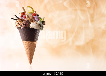 Assortimento di frutta naturale gelato con sfondo di vapore. Elevazione sul piano riflettente e guarnita con frutta e la lavorazione di prodotti. Vista frontale Foto Stock