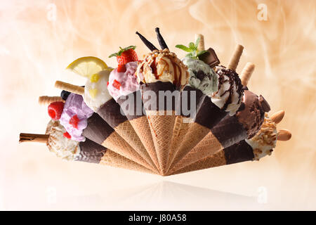 Assortimento di frutta naturale gelato con sfondo di vapore. Elevazione sul piano riflettente e guarnita con frutta e la lavorazione di prodotti. A ventaglio Foto Stock