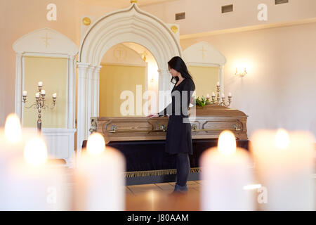 Triste donna con la bara al funerale nella chiesa Foto Stock