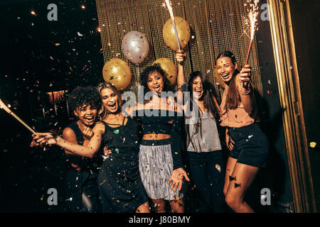 Colpo di un gruppo di ragazze in discoteca avente un grande tempo. Il gruppo di amici di sesso femminile partying in pub. Foto Stock