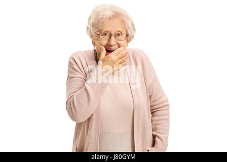 Sorpreso donna matura tenendo la sua mano contro la sua bocca e guardando la telecamera isolata su sfondo bianco Foto Stock