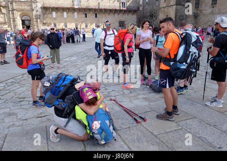 Il momento di emozione come pellegrini arrivano nella piazza della Cattedrale di Santiago de Compostela in Spagna settentrionale dopo aver camminato il Camino de Santiago Foto Stock