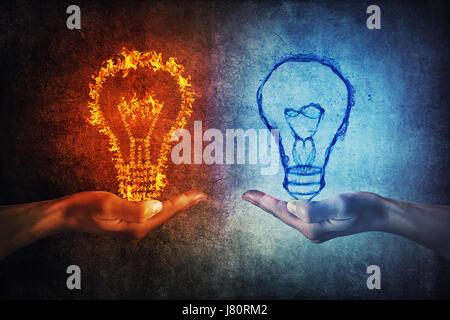 Due mani umane tenendo flaming e spruzzi lampadine su sfondo grigio. Pensando di scambio e di idea di partenariato il concetto di business. Il fuoco contro Foto Stock