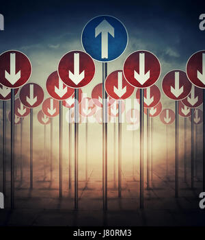 Immagine concettuale con un sacco di segnaletica stradale verticale diretto verso il basso e una freccia verso l'alto. Viaggio strategico, difficile dilemma, decisione life. Foto Stock