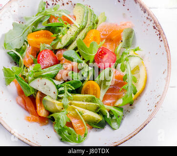 Salmone fresco con insalata di pomodori ciliegini, rucola, spinaci e avocado. Vista da sopra Foto Stock