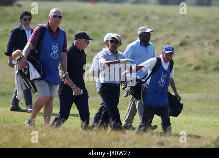 Ex presidente degli Stati Uniti Barack Obama parla con Sir Tom Hunter (black hat) come essi si muovono al foro successivo presso il St Andrews Golf Club, vicino a Dundee in Scozia. Foto Stock