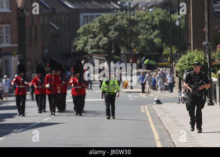 Un agente di polizia armato cammina accanto alla modifica della cerimonia di guardia al di fuori del Castello di Windsor in Berkshire, dopo che il caso era stato annullato il mercoledì in scia dell'attacco di Manchester. Foto Stock