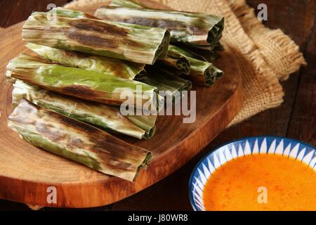 A Otak otak, indonesiano torta di pesce avvolto in foglie di banana. Un popolare snack a Jakarta. Foto Stock