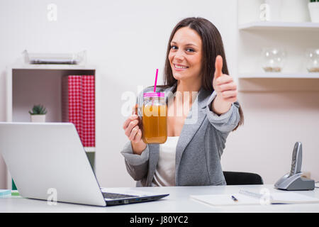 Giovane imprenditrice è frullato da bere nel suo ufficio. Foto Stock