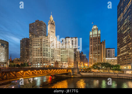 Serata foto di Chicago riverwalk con vedute del fiume Chicago, passando per barche e già edifici illuminati USA Foto Stock