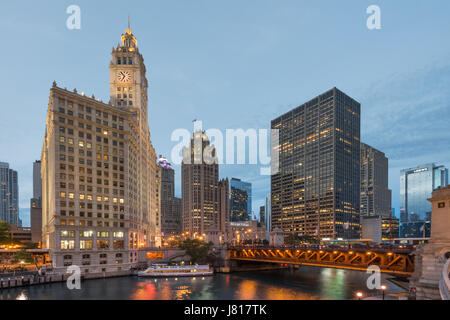 Serata foto di Chicago riverwalk con vedute del fiume Chicago, passando per barche e già edifici illuminati USA Foto Stock