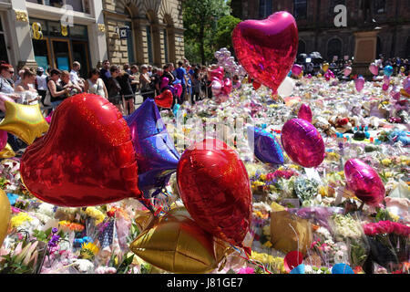 Un mare di palloncini e tappeto di fiori St rna quadrato come persone in lutto portare omaggi al 22 vittime e la città di Manchester scritto sul marciapiede in St rna Square nel centro cittadino di Manchester come persone celebrare e tristi. Salman Abedi è esplosa una bomba suicidi e beleived è di essere parte di un libico terrore basato su cella. Foto Stock