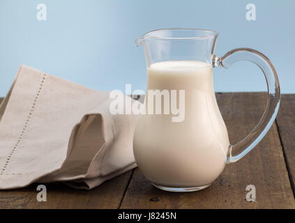 Latte intero in caraffa di vetro sul tavolo di legno - Sfondo con lo spazio di testo Foto Stock
