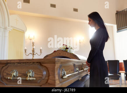 Triste donna con la bara al funerale nella chiesa Foto Stock