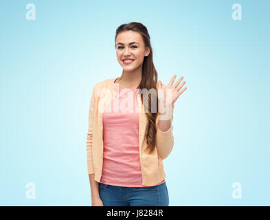 Sorridenti giovane donna agitando la mano su bianco Foto Stock