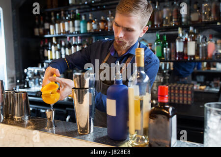 Il barman con shaker, alcol e jigger presso il bar Foto Stock