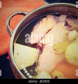 Preparare in casa la zuppa di pollo - brodo. Pentola sulla stufa in cucina con gli ingredienti per cucinare. Foto Stock
