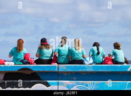 Gli scolari spagnolo di mangiare il pranzo al sacco sulla parete del mare. Foto Stock