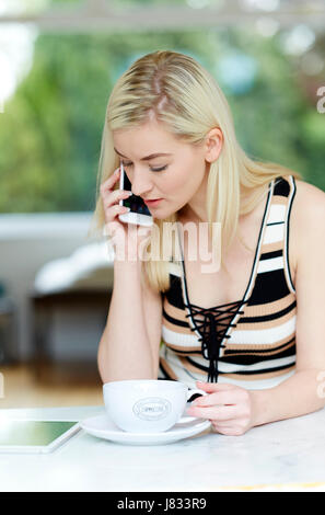 Donna che guarda interessato a parlare al telefono Foto Stock