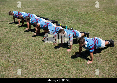 Elevato angolo di visione dei giocatori facendo spingere ups al campo erboso sulla giornata di sole Foto Stock