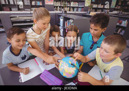 Schoolkids globo di studiare in biblioteca a scuola Foto Stock