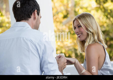 Vista posteriore dell'uomo propone giovane donna al ristorante Foto Stock