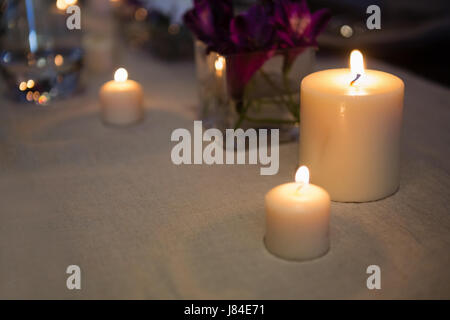 Close up di candele accese sul tavolo al ristorante Foto Stock