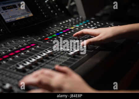 Le mani delle donne ingegnere audio con mixer audio in studio di registrazione Foto Stock