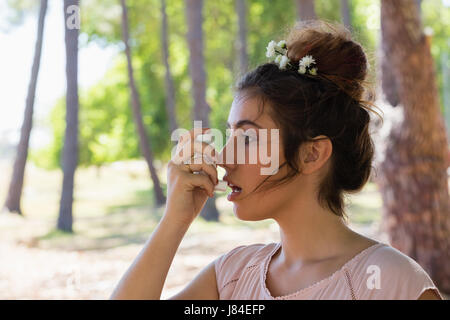 Giovane donna con asma inalatore nel parco Foto Stock