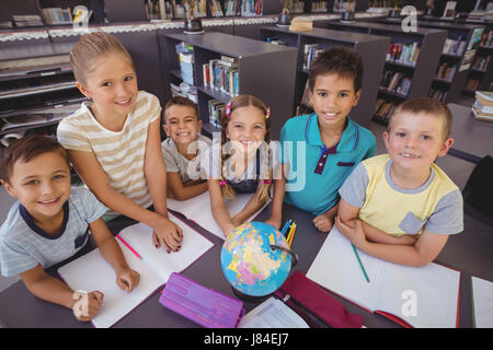 Schoolkids globo di studiare in biblioteca a scuola Foto Stock