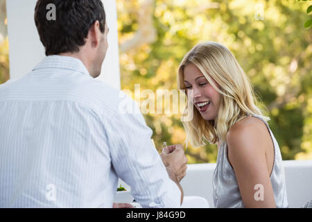 Vista posteriore dell'uomo propone felice giovane donna al ristorante Foto Stock