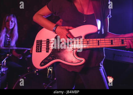 La sezione centrale del chitarrista femmina a suonare la chitarra con il batterista in discoteca Foto Stock