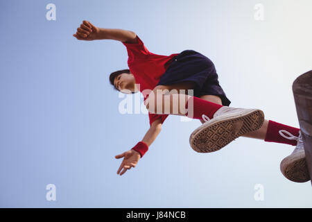 Determinato ragazzo saltando sopra un ostacolo in boot camp Foto Stock