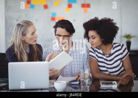 Fiducioso la gente di affari con tavoletta digitale durante la creazione delle strategie in ufficio creativo Foto Stock