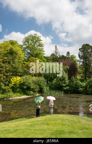 Due signore accanto al lago di Koi a Thornbridge alle prese hall gardens vicino grande Longstone, Derbyshire, in Inghilterra. Foto Stock