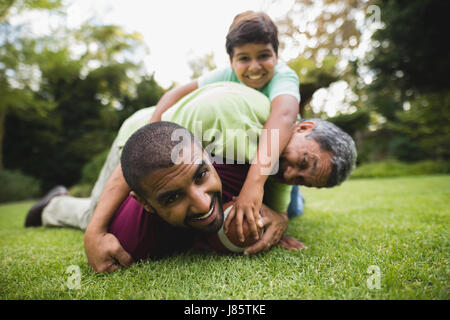 Ritratto di felice multi generazione famiglia giocando a rugby presso il park Foto Stock