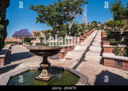 Almeria, Spagna - 20 Maggio: Medievale fortezza moresca Alcazaba in Almeria, accesso alla Alcazaba con giardini e alberi di diverse specie, fontana Foto Stock