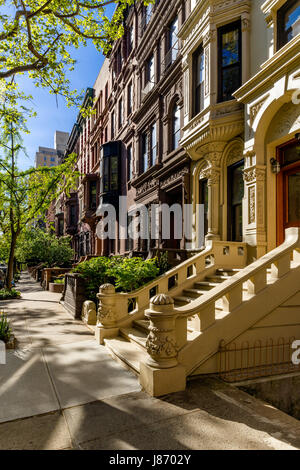 Fila di case di arenaria con gradini di casa ed ornamento nella luce del mattino. Upper West Side Street, Manhattan New York City Foto Stock