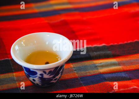 Cinese del tè sulla tazza tradizionale tessuto rosso Foto Stock