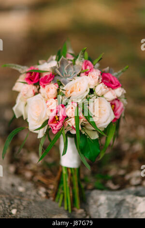 Wedding bouquet di rose e peonie e succulente sulle rocce. Nozze in Montenegro, dell'Adriatico. Foto Stock