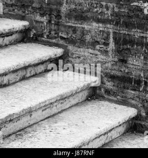 Vecchia scalinata in cemento va vicino a un muro di mattoni, foto in bianco e nero Foto Stock